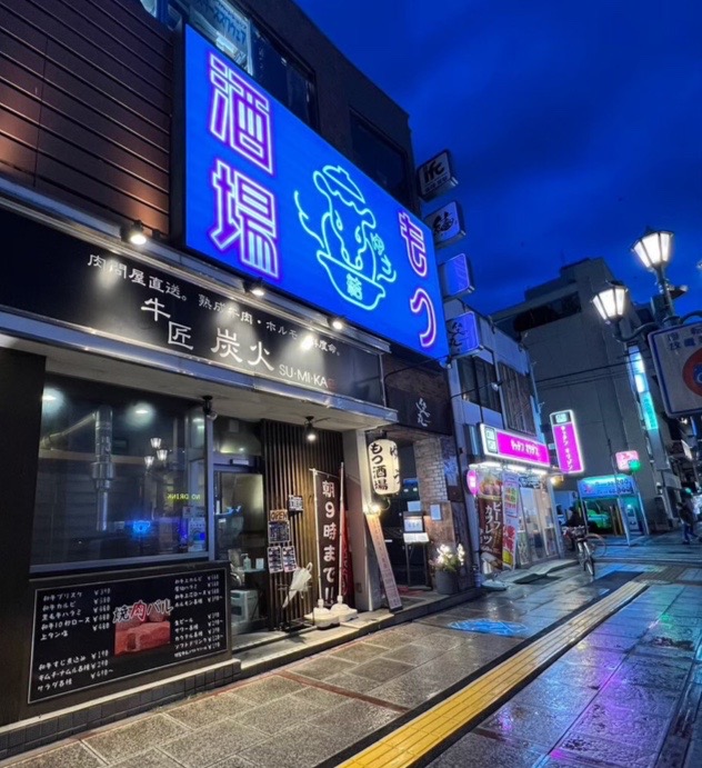 青い看板が目印のもつ酒場 結の外観と入口
